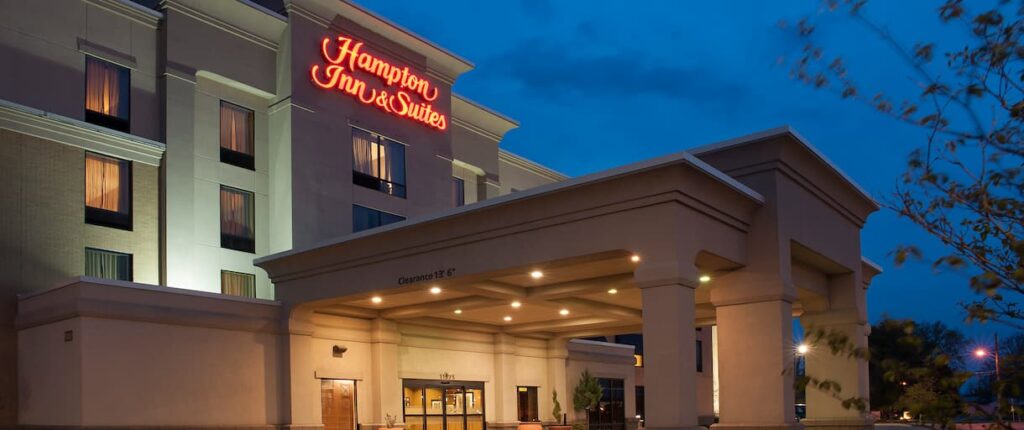 photos of the exterior of a Hampton Inns & Suites at night with the sign. illuminated